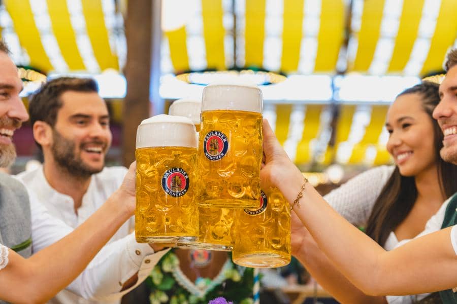 Men and women clicking beer glasses during Oktoberfest at Carowinds amusement park, a fine Six Flags Entertainment Corp. park.